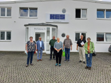 Besucher stehen vor einem Firmengebäude